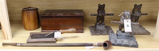 Three carved wood bear pipe racks, a 19th century tobacco cutter, a silver-mounted long pipe and sundries,